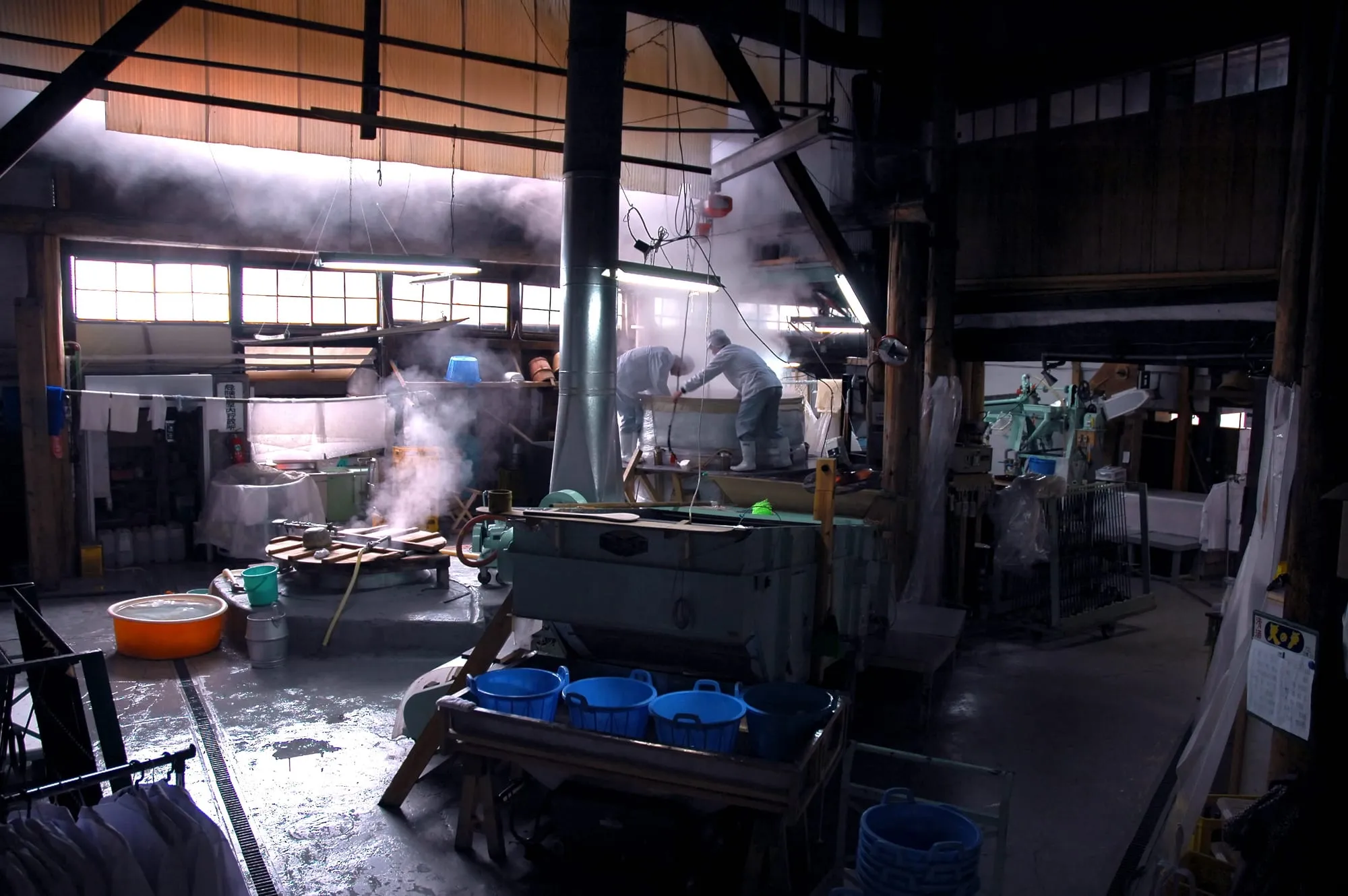 蒸米から湯気の上がる酒蔵の仕込みの風景